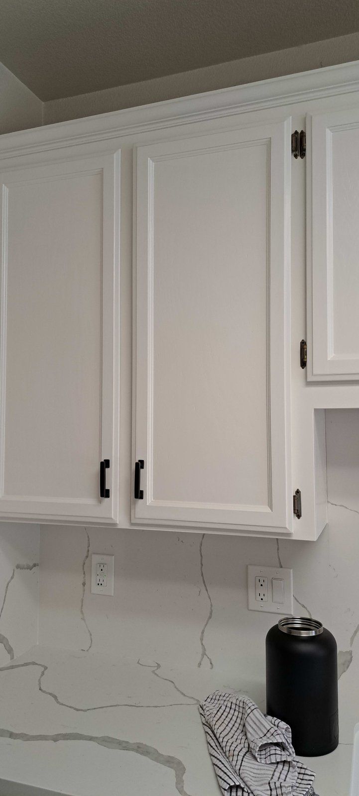 A kitchen with white cabinets and a white counter top.