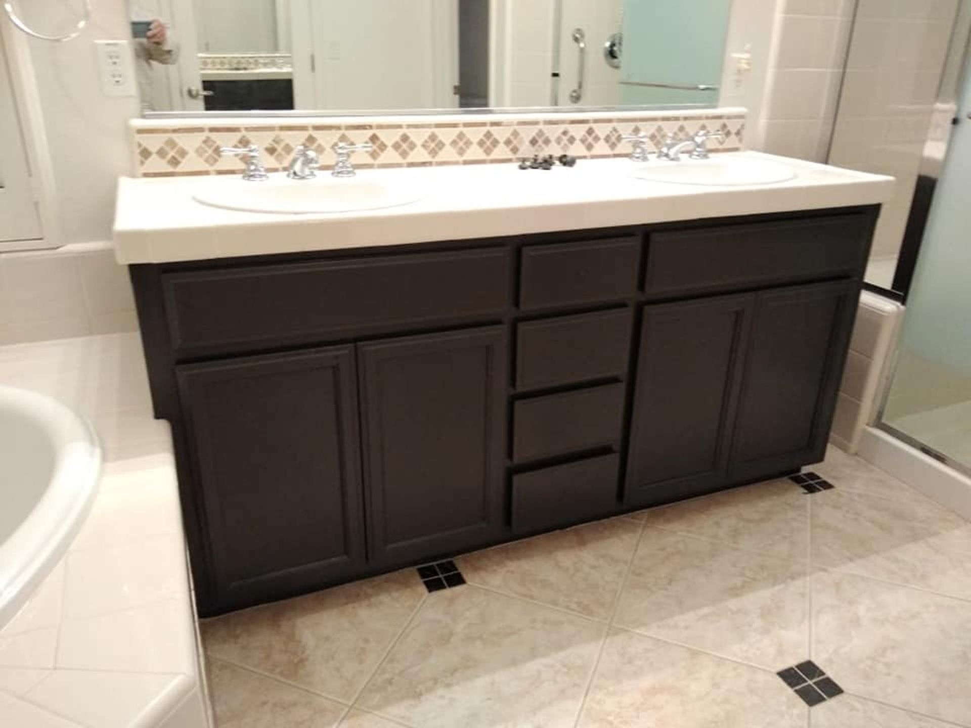 A bathroom with two sinks , a mirror and a bathtub.