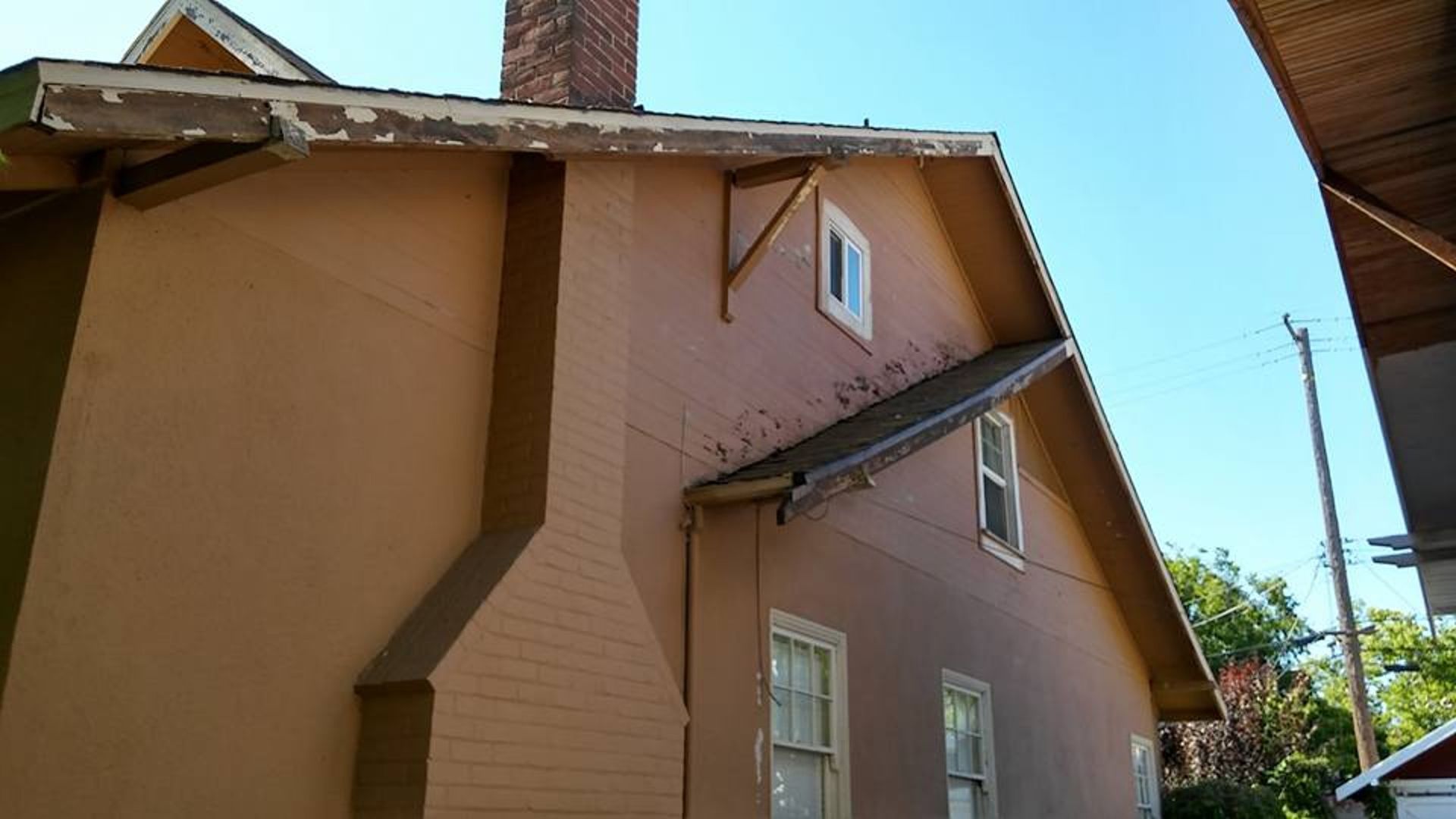 A brown house with a chimney on the side of it