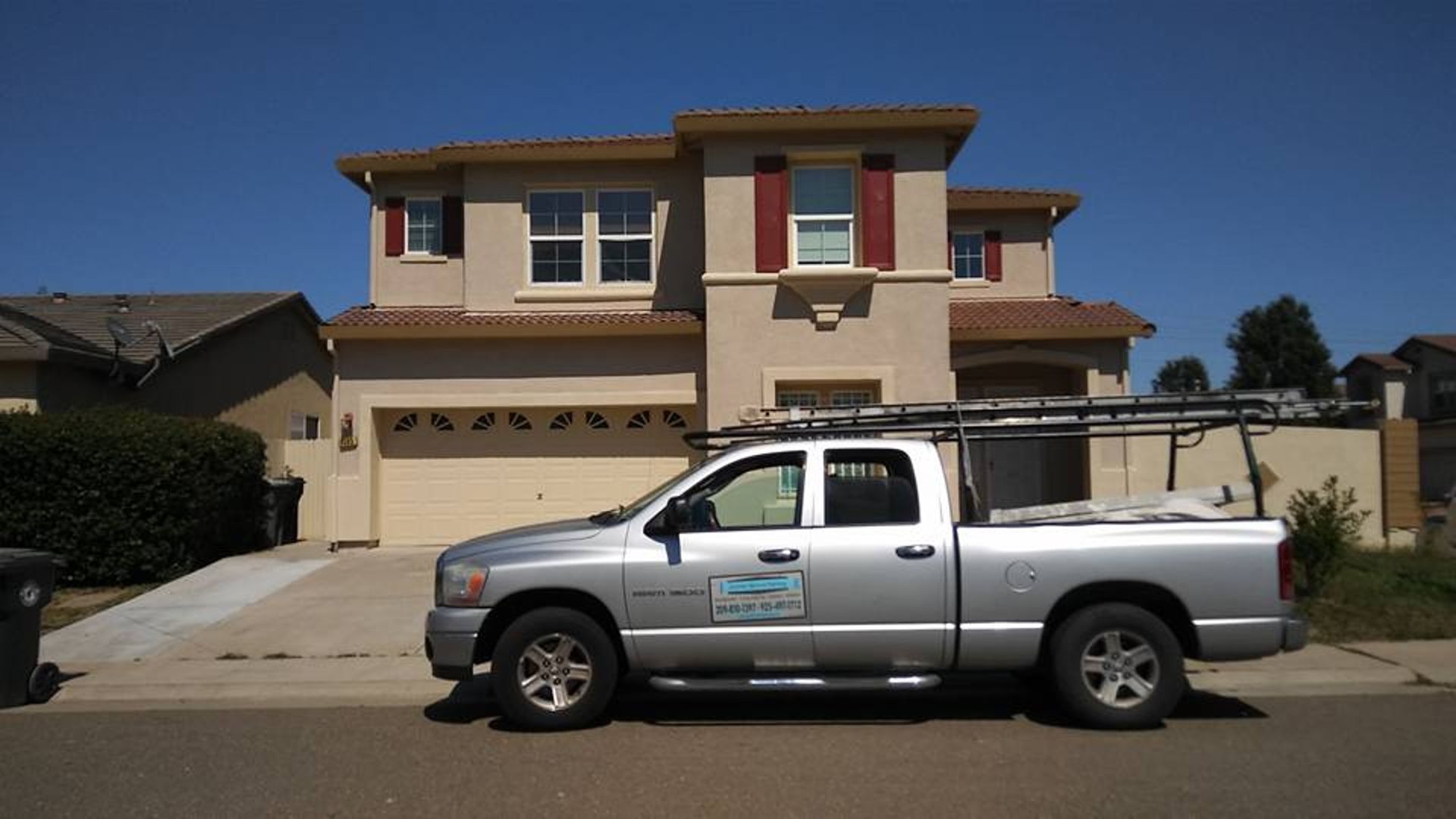 A silver truck is parked in front of a house