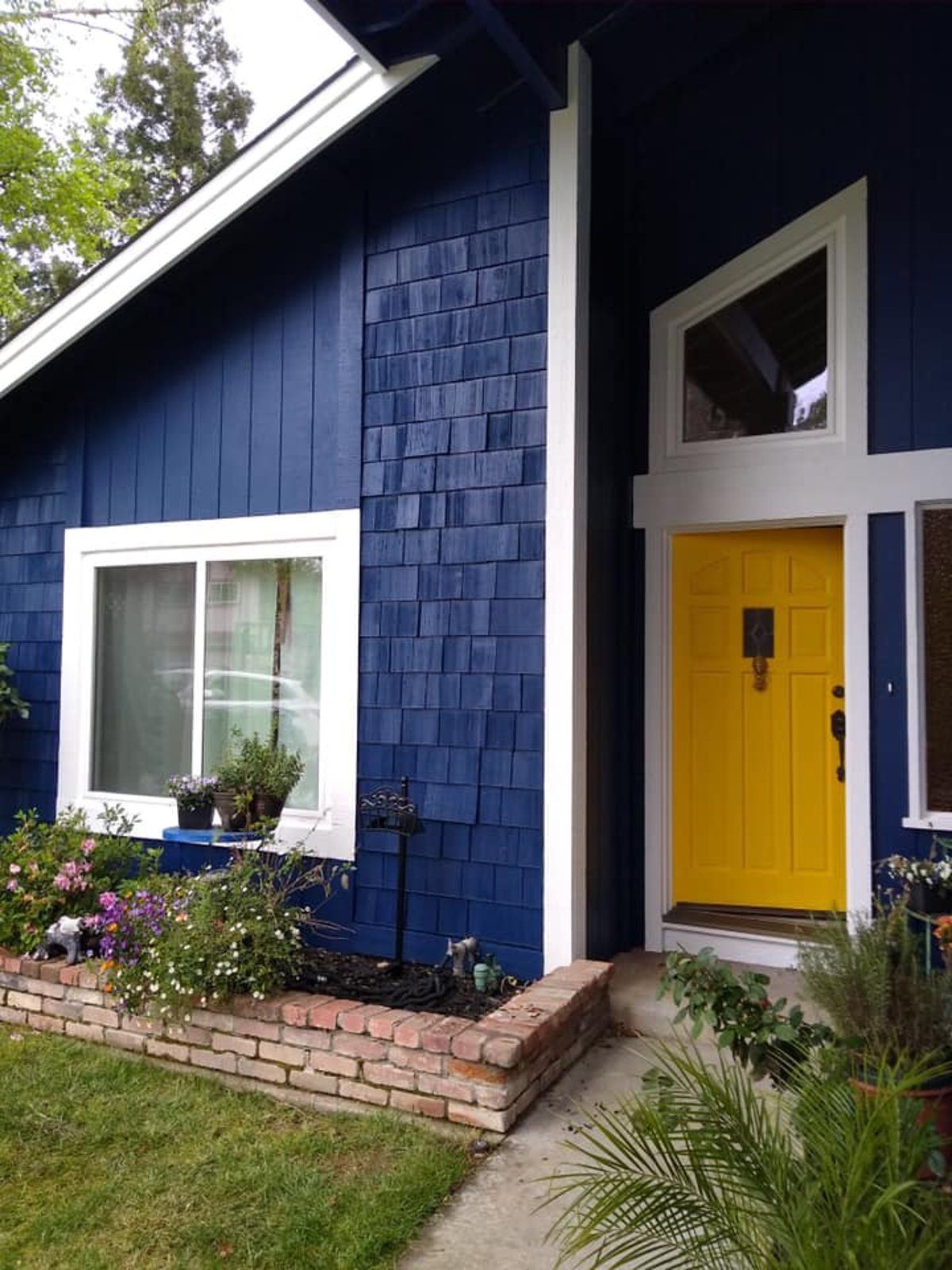 A blue house with a yellow door and windows