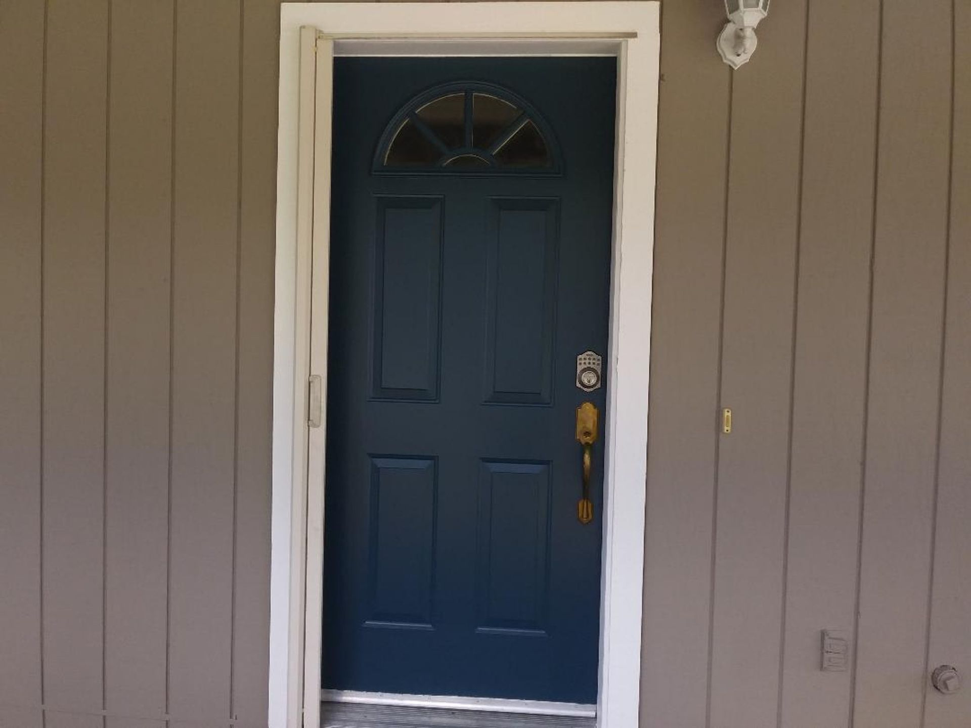 A blue door with a white trim is on a house.