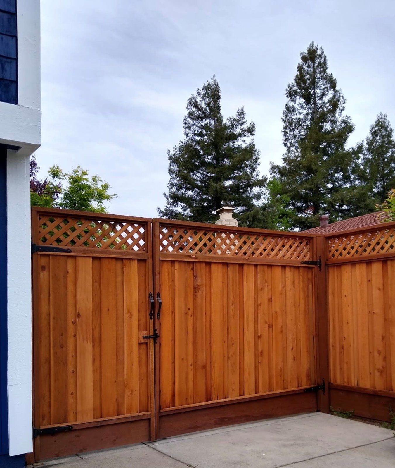 A wooden fence with a gate in front of a house