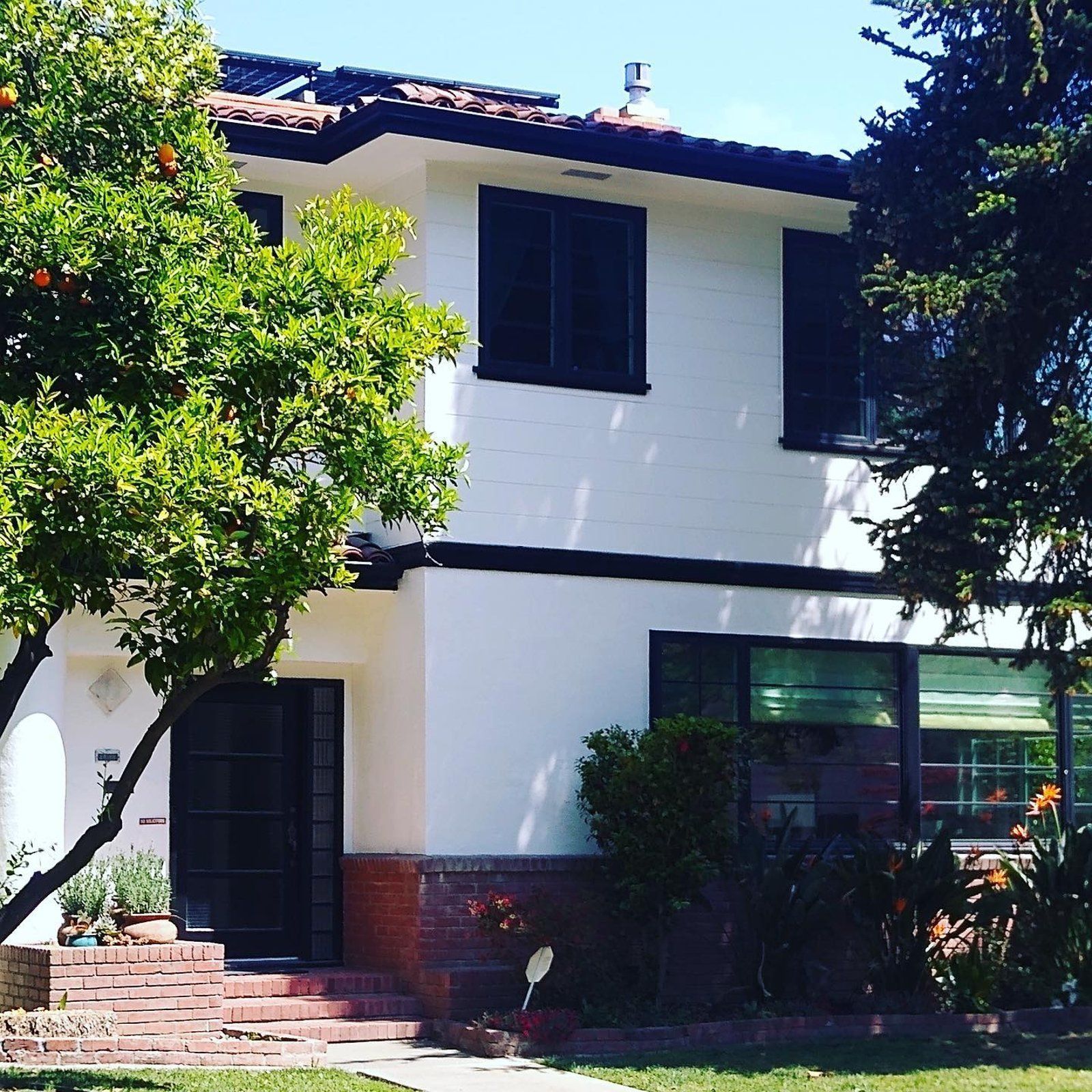 A white house with a tree in front of it