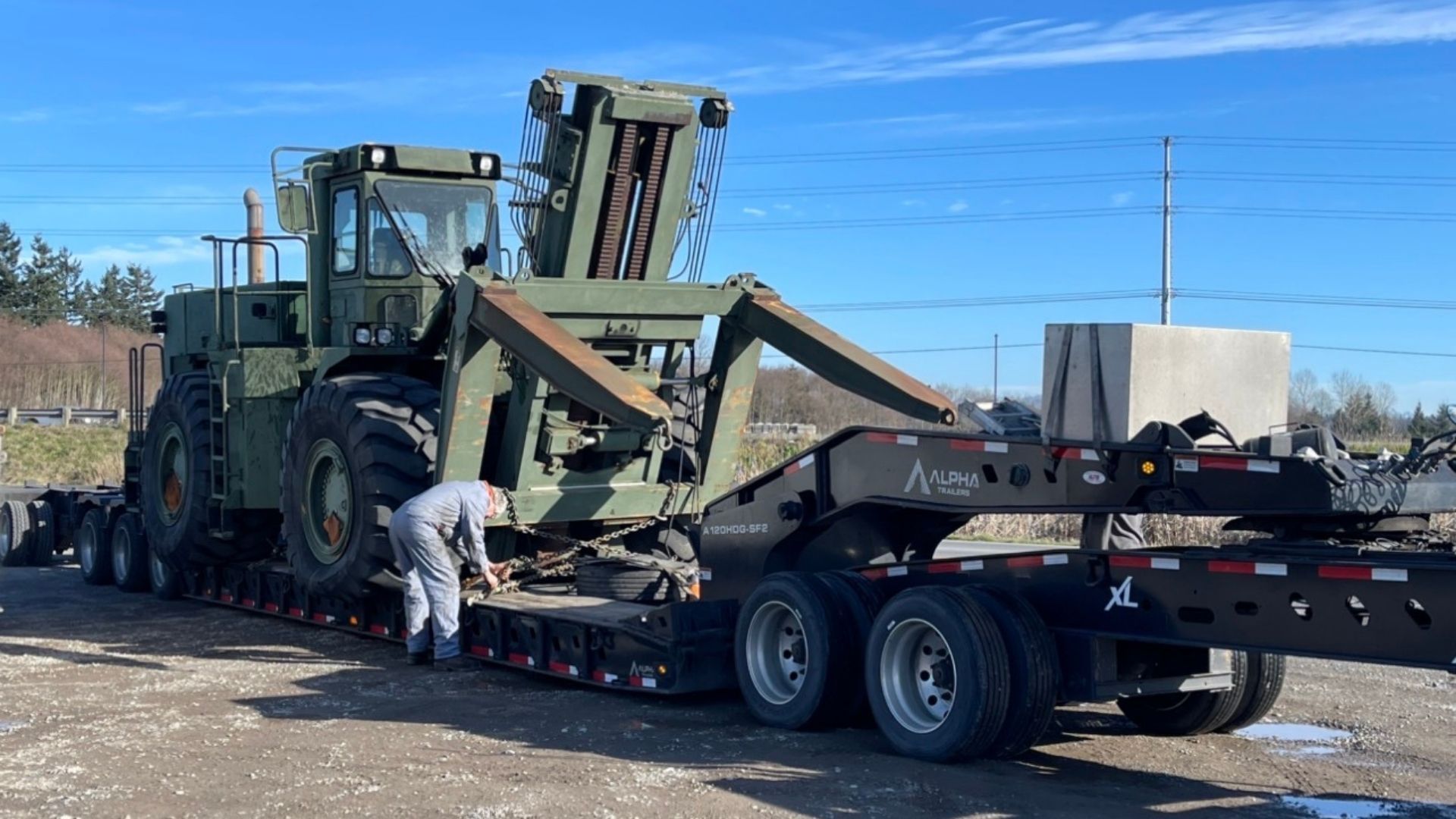 White car driving on a highway with traffic; buildings in the background.