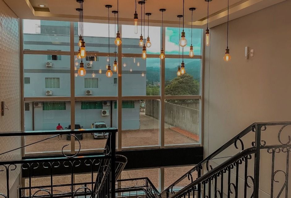 Uma escada com luzes penduradas no teto e uma grande janela: Hotel Bergozza