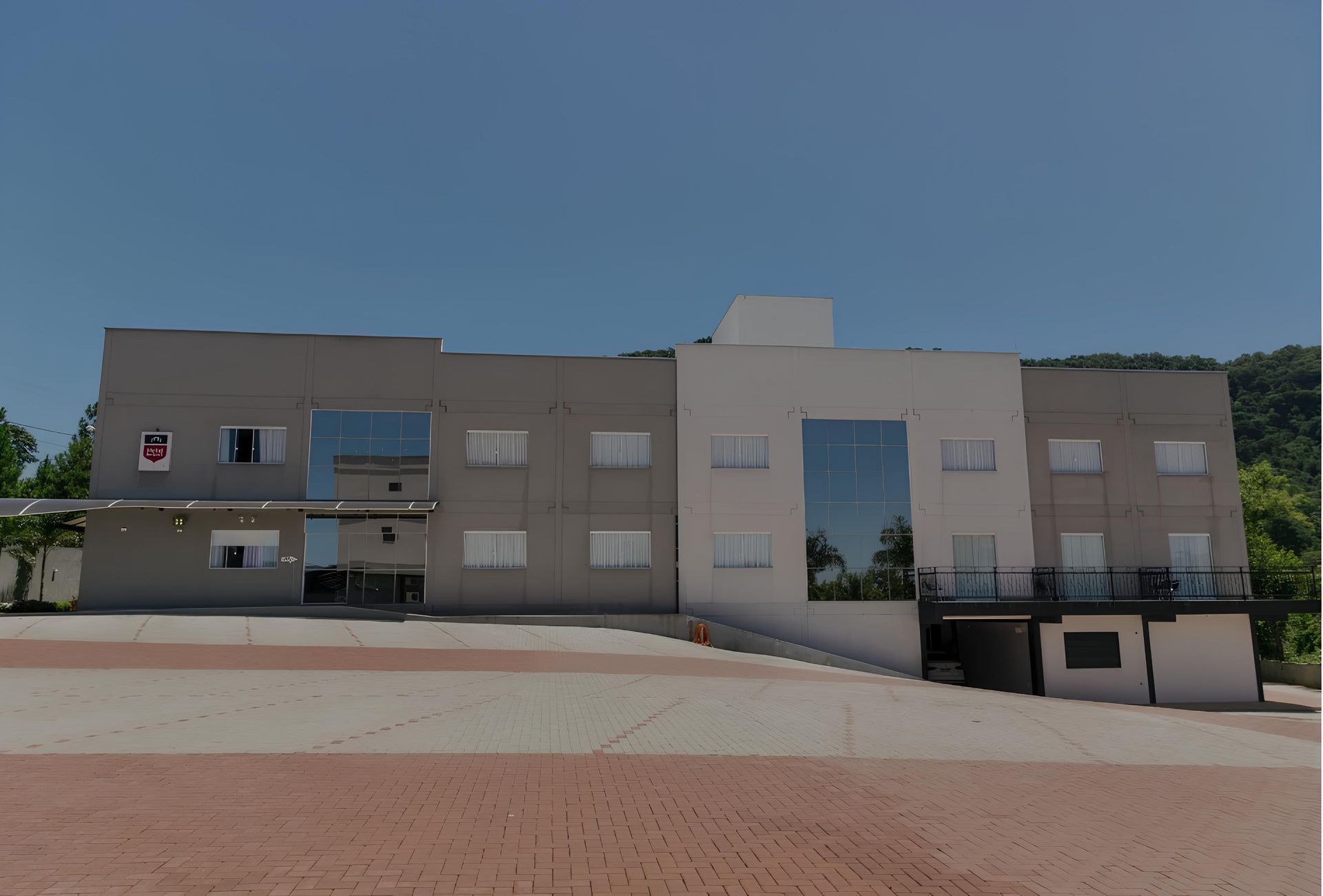 Um grande edifício com muitas janelas e uma varanda: Hotel Bergozza
