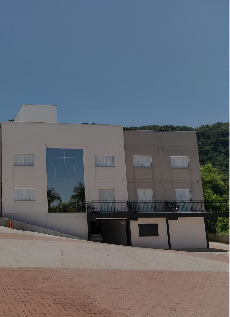 Um grande edifício branco com uma varanda no topo: Hotel Bergozza