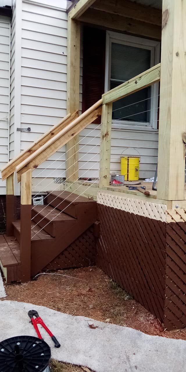 Brown porch stairs and railing under construction, wooden accents and latticework.