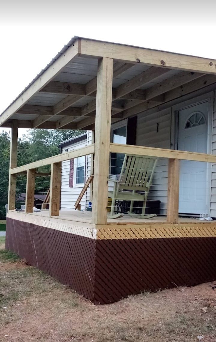 Wooden porch with roof, railing, and skirting. Brown latticework covers the lower portion.