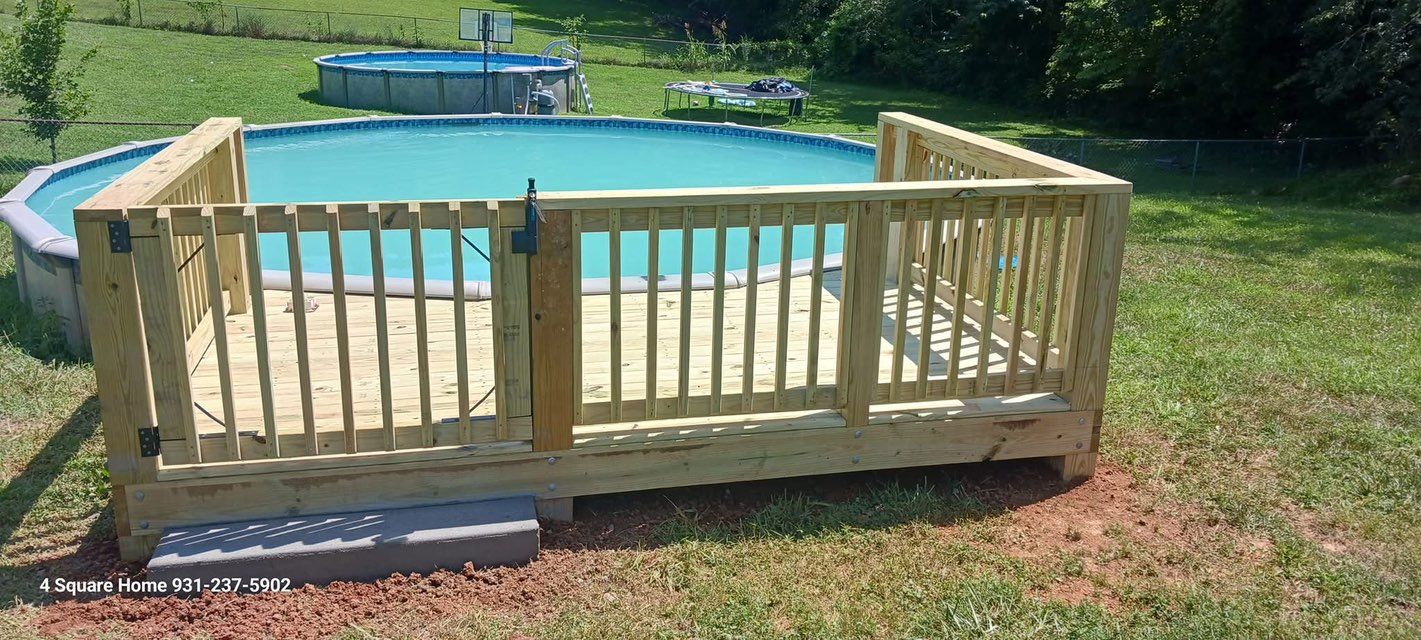 Wooden deck with gate surrounding an above-ground pool; green lawn and another pool are in the background.