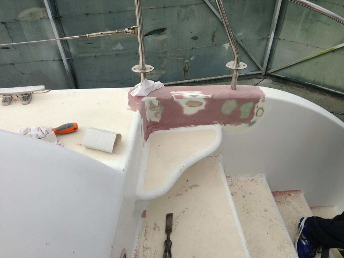 A Person Is Working on The Side of A Boat — Ashby Boat Builders In Buddina, QLD