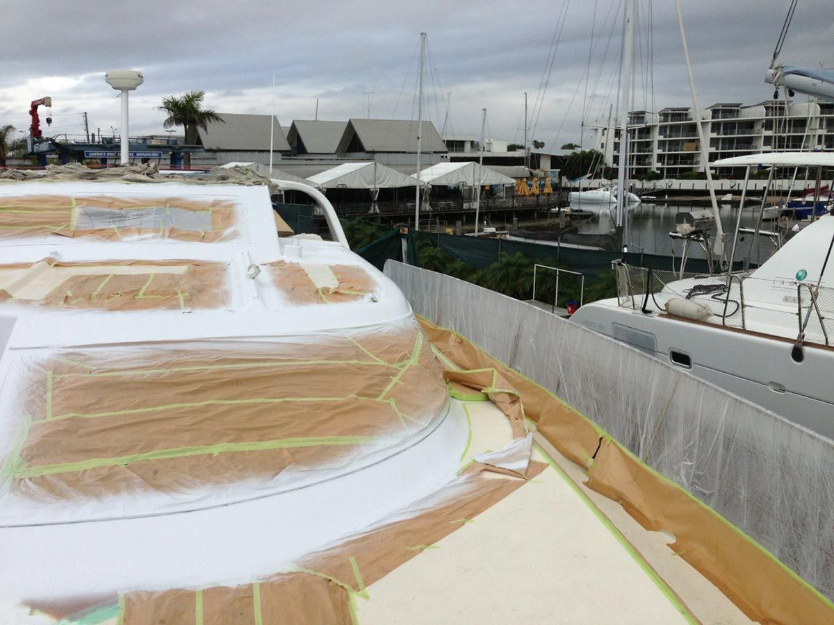 A Boat Is Being Painted White in A Marina — Ashby Boat Builders In Buddina, QLD