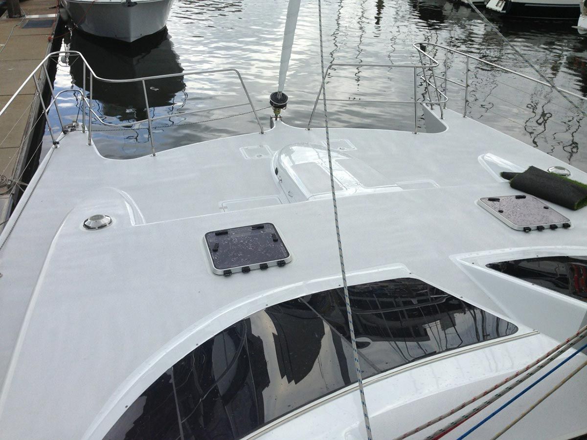 A White Boat Is Docked at A Dock with A Boat in The Background — Ashby Boat Builders In Buddina, QLD