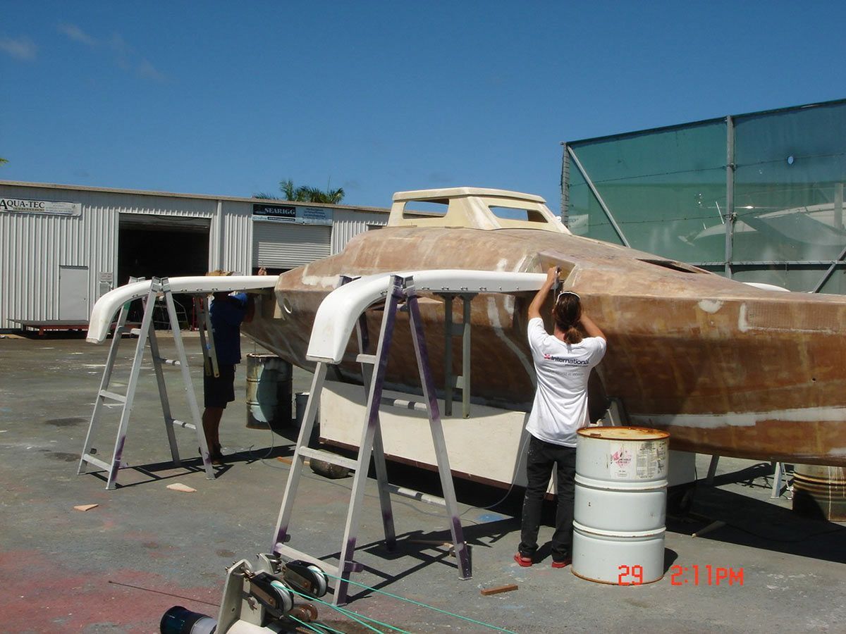A Man in A White Shirt Is Working on A Boat — Ashby Boat Builders In Buddina, QLD
