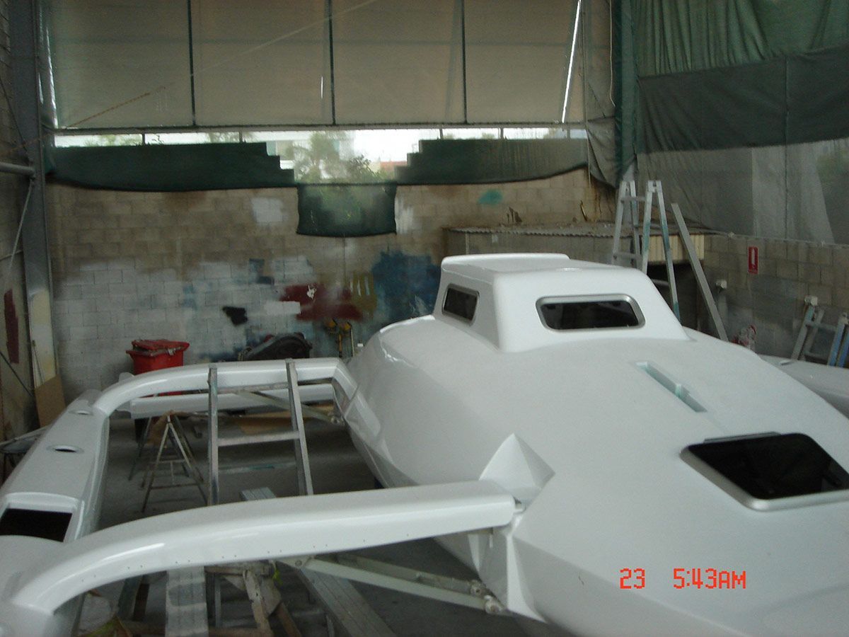 A White Boat Is Being Built in A Shed — Ashby Boat Builders In Buddina, QLD