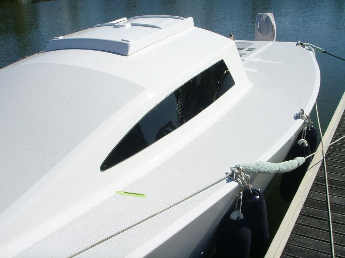 A Small White Boat Is Docked at A Dock — Ashby Boat Builders In Buddina, QLD