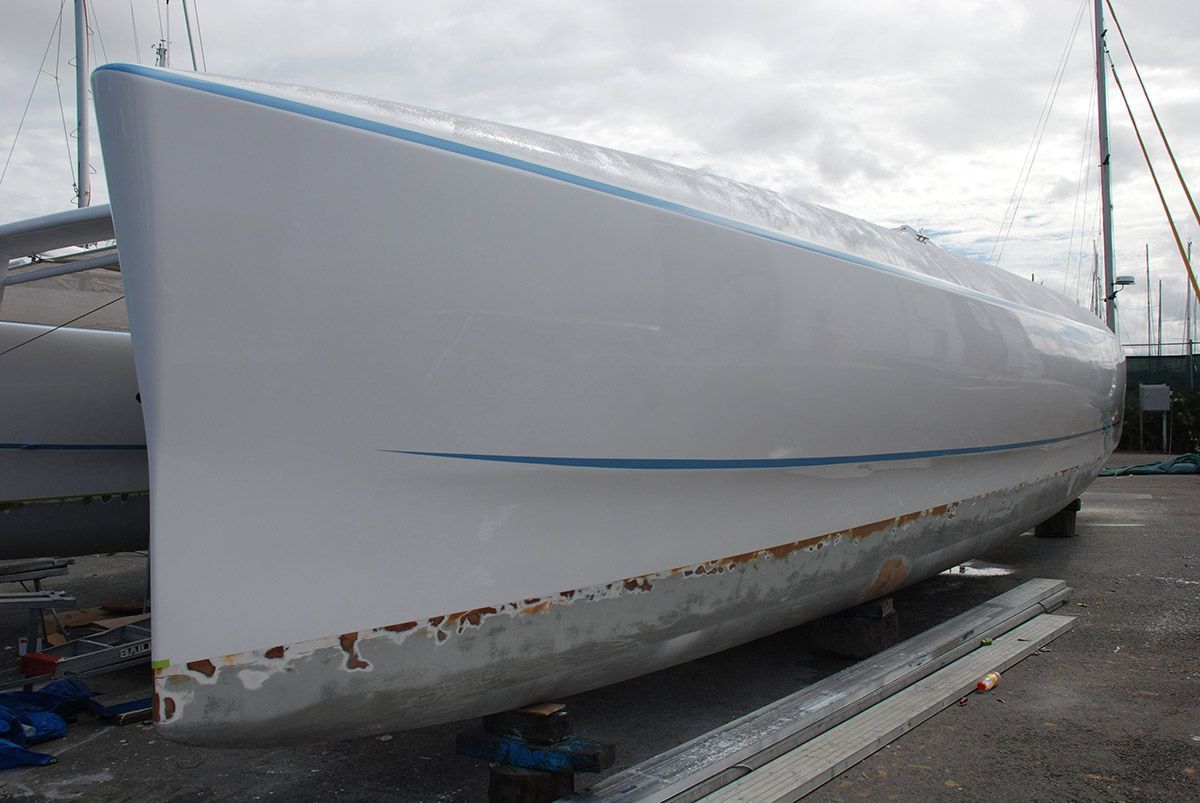 A White Boat with A Blue Trim Is Parked on The Side of The Road — Ashby Boat Builders In Buddina, QLD