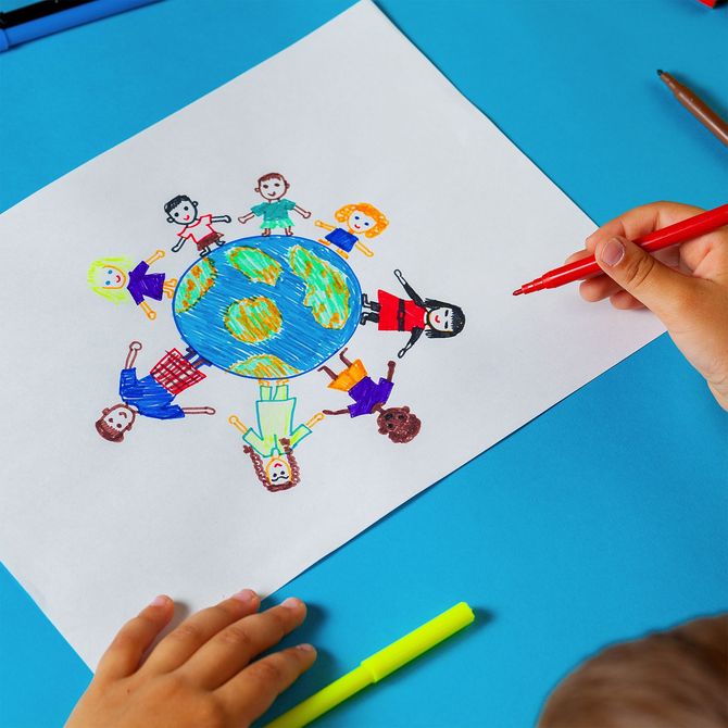 A child is drawing a picture of people around a globe