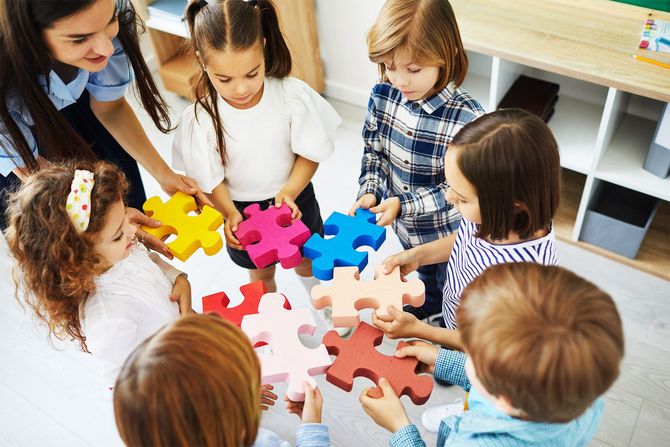 A group of children are playing with puzzle pieces in a circle.