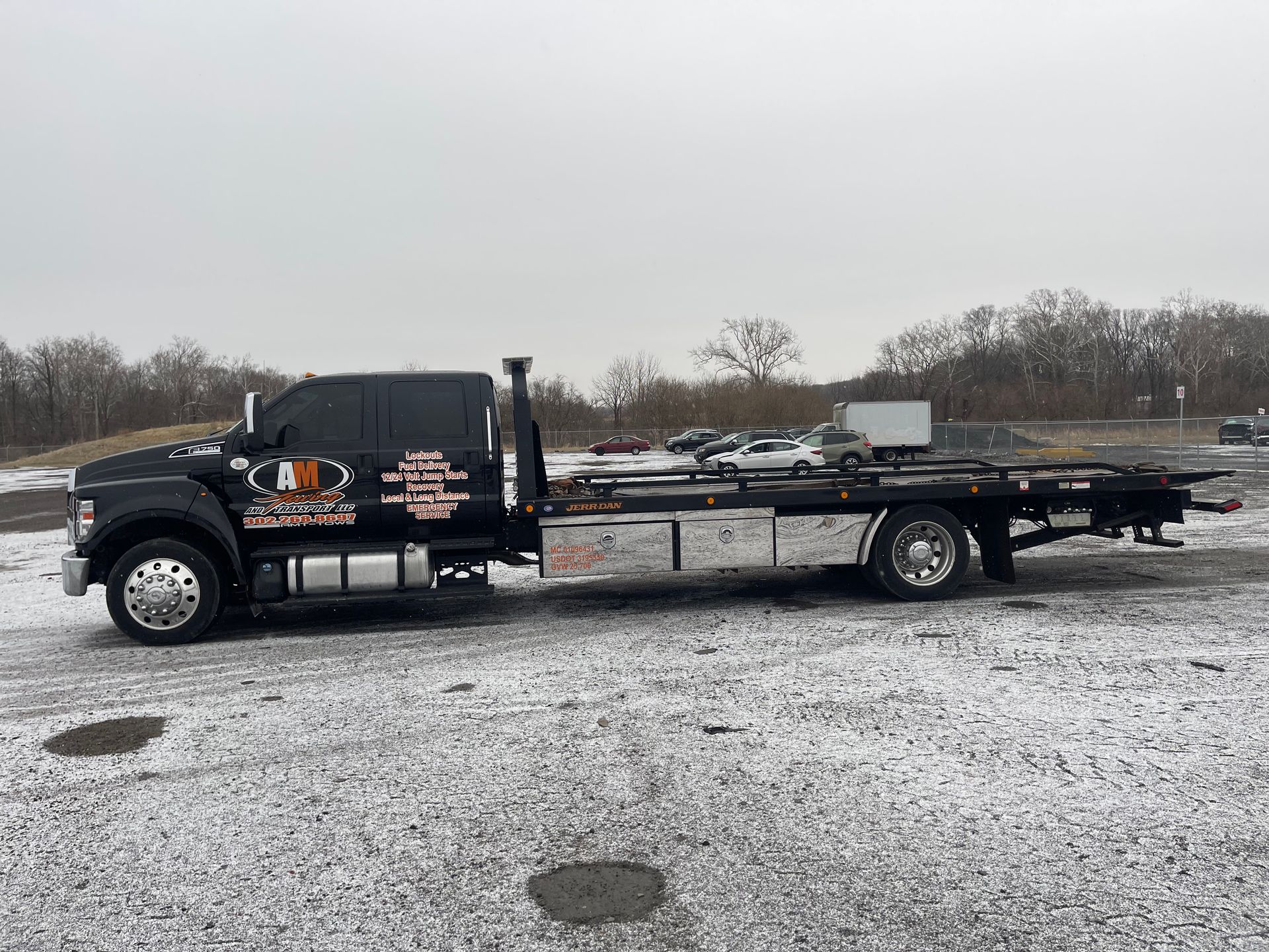 Man in safety vest pouring gas into a white car on the side of a road.