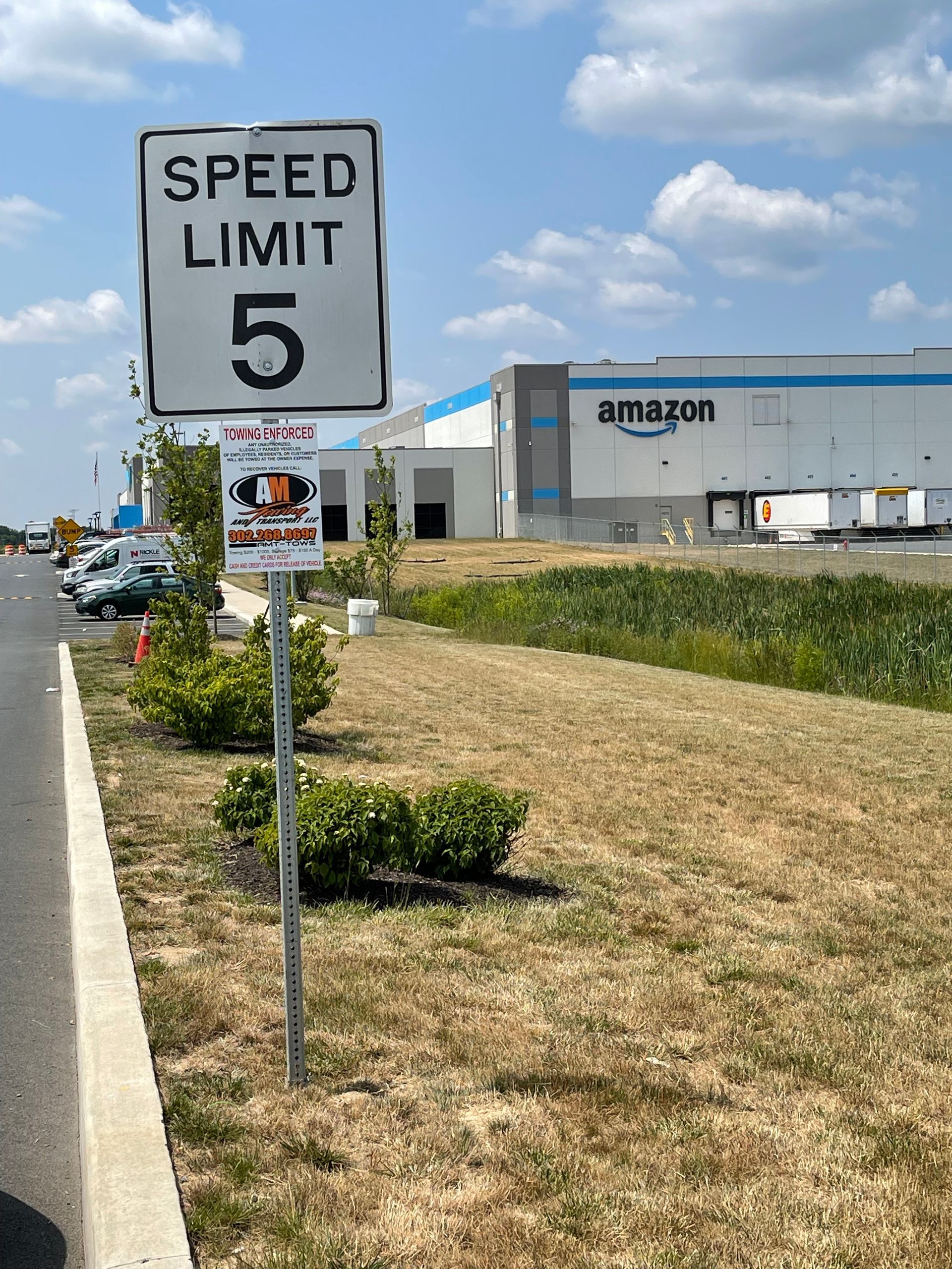 Speed limit 5 sign in front of an Amazon warehouse.