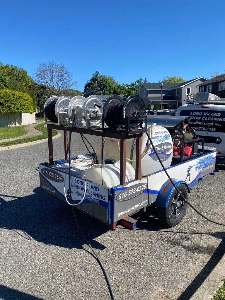 A trailer with a boat on it is parked on the side of the road.