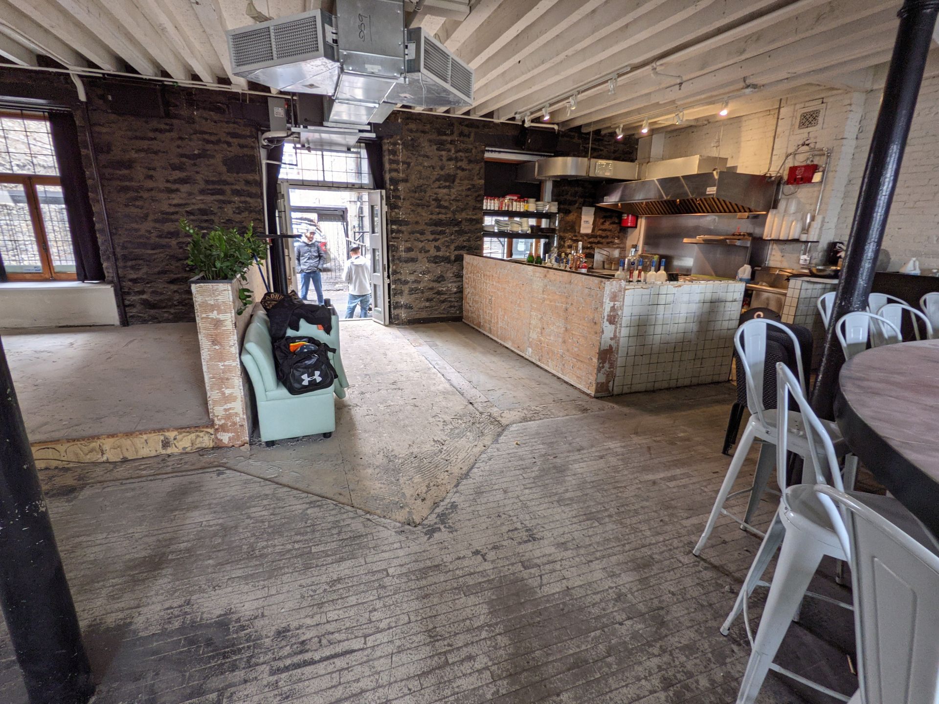 Un restaurant avec tables et chaises et un mur de briques.