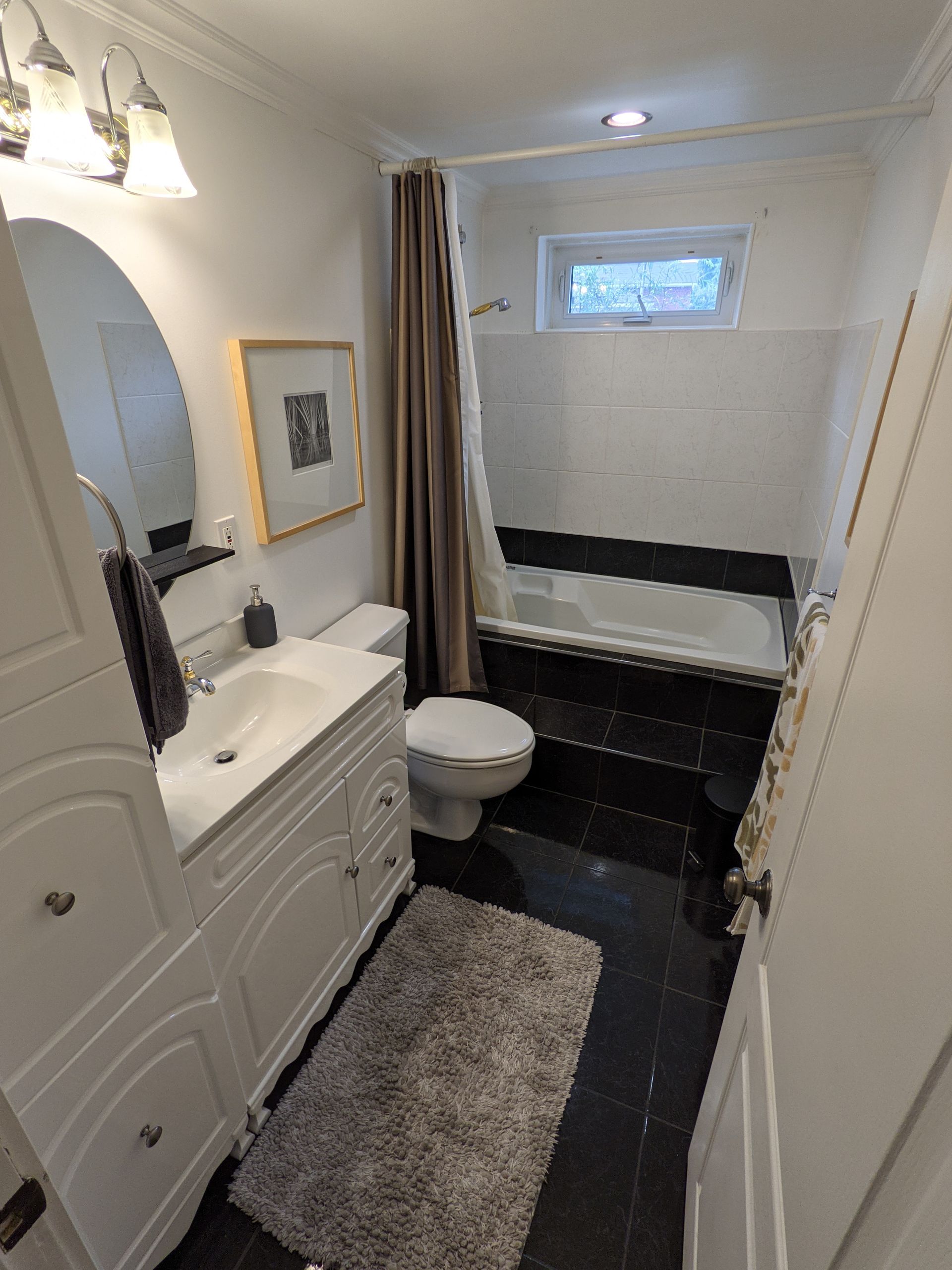 Une salle de bain avec toilettes, lavabo et baignoire.