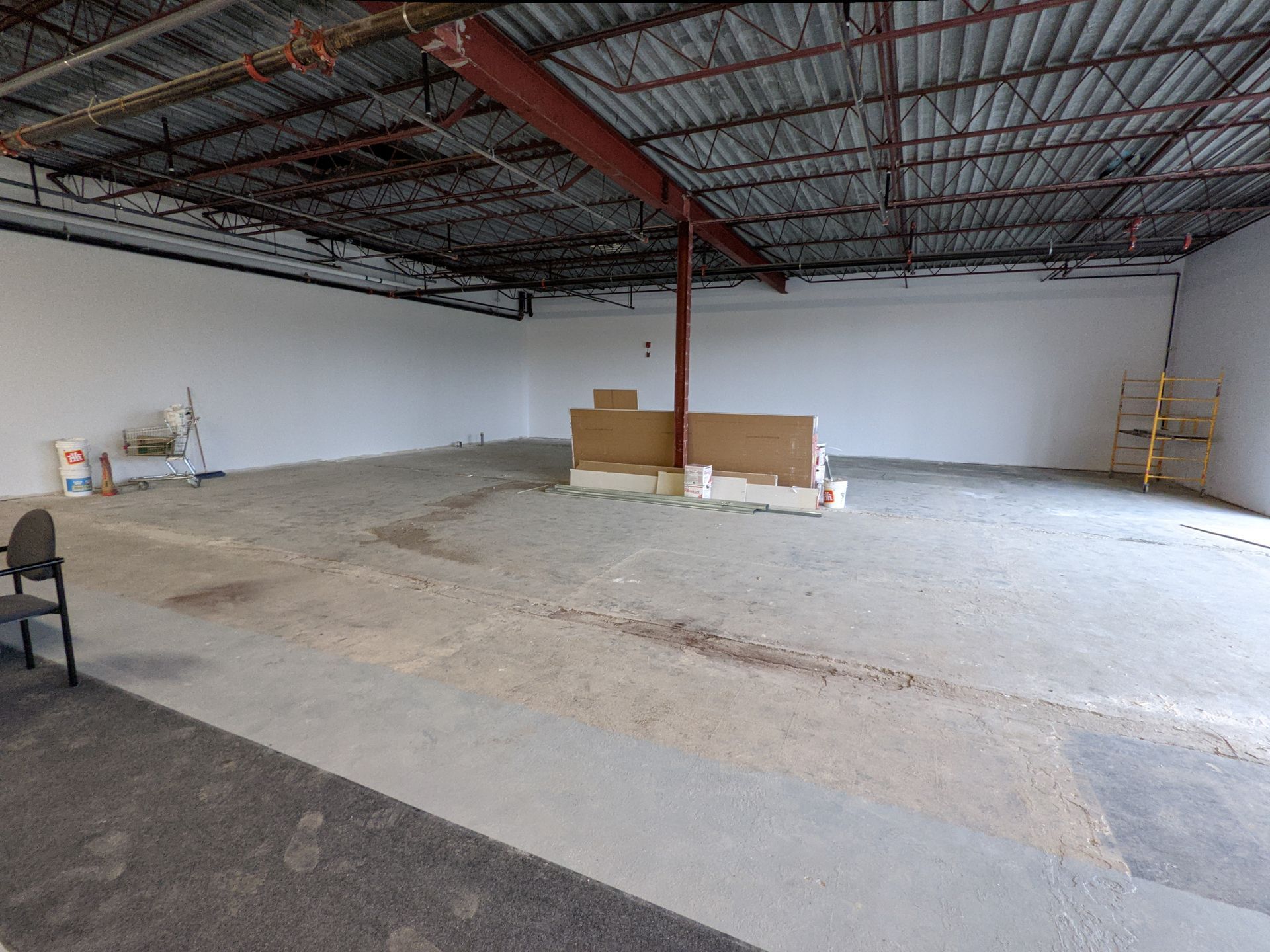 Un grand entrepôt vide avec un toit métallique