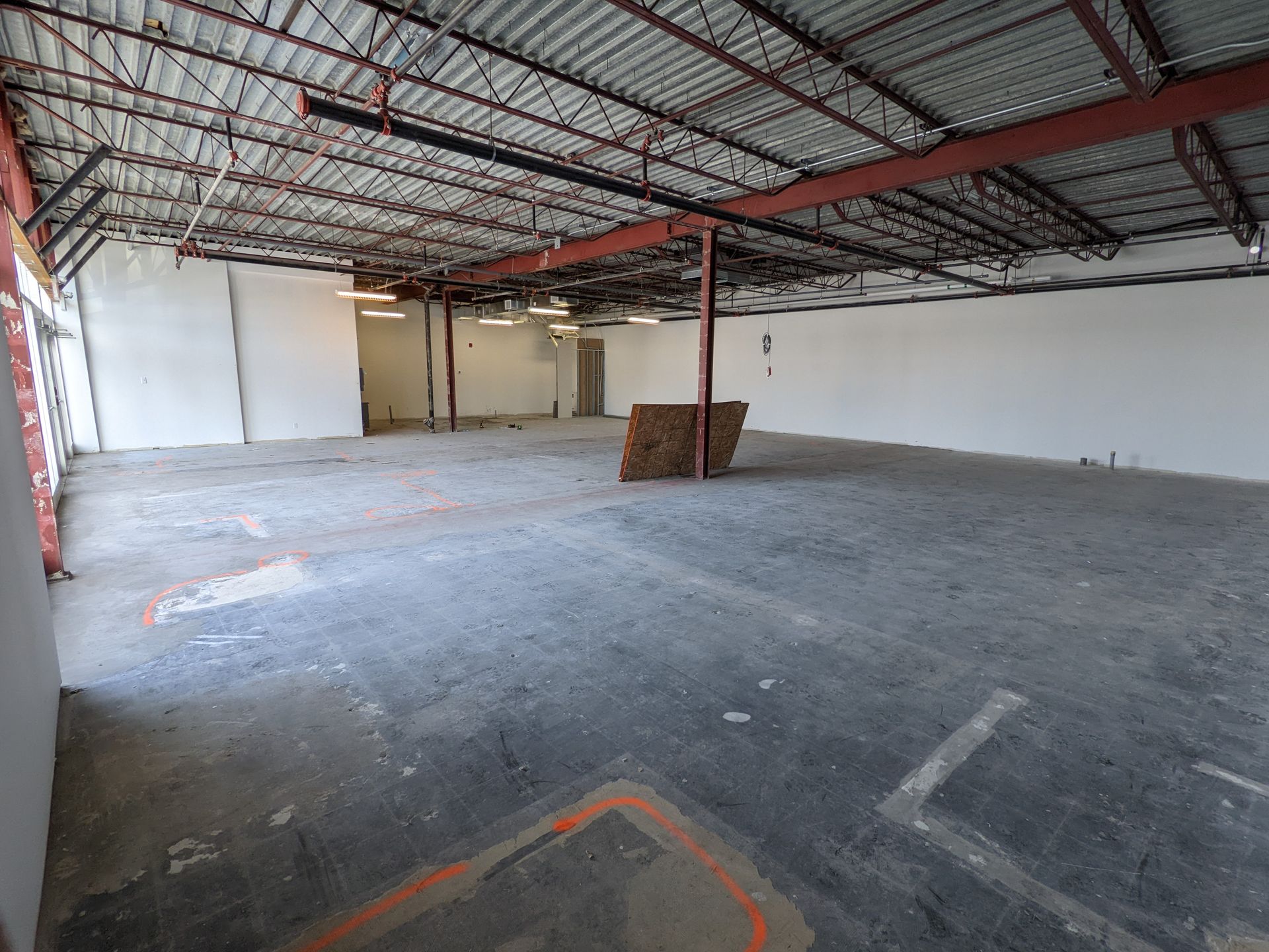 Une grande pièce vide avec un toit en métal et des murs blancs