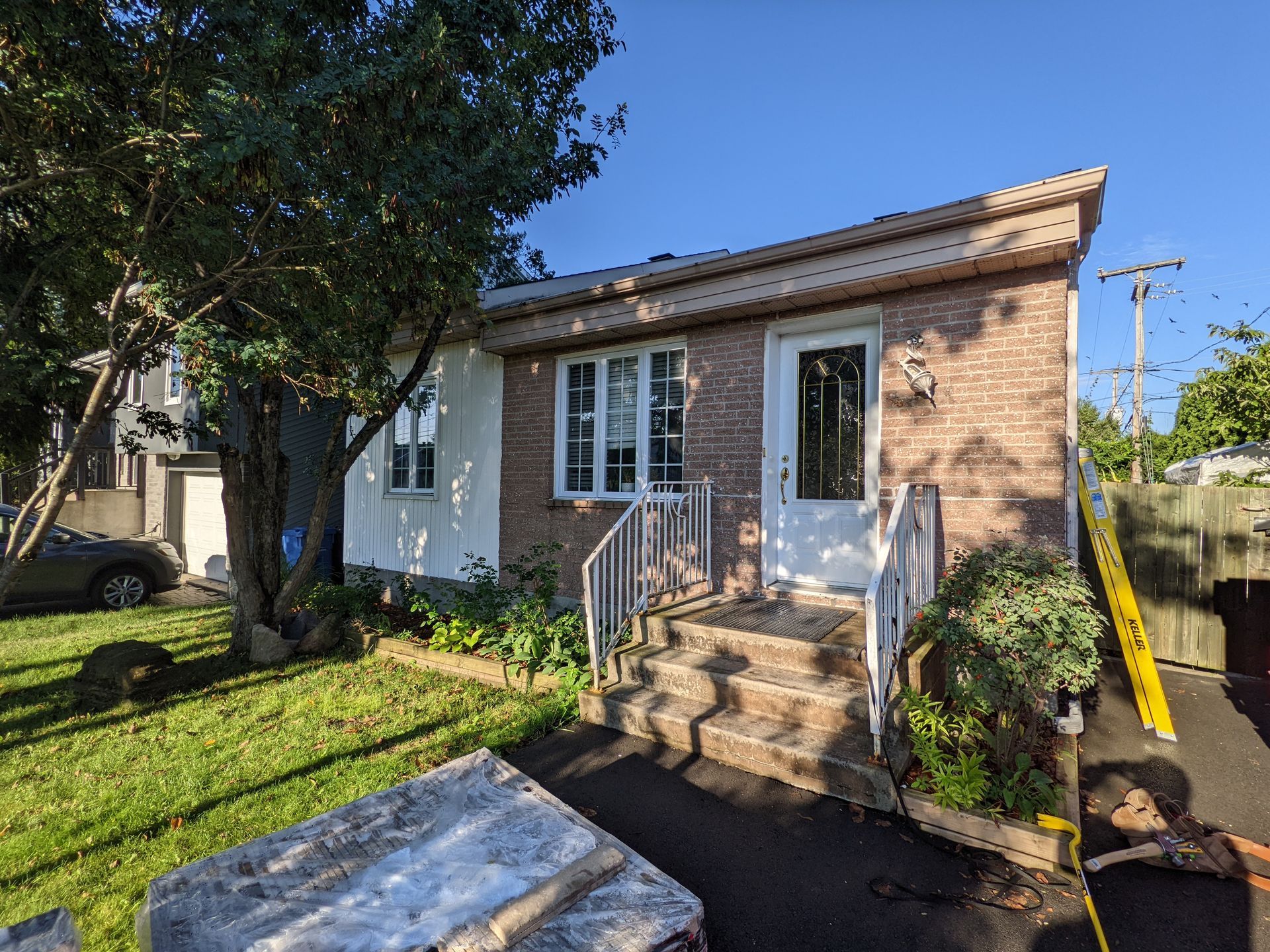 Une petite maison en brique avec une voiture garée devant.