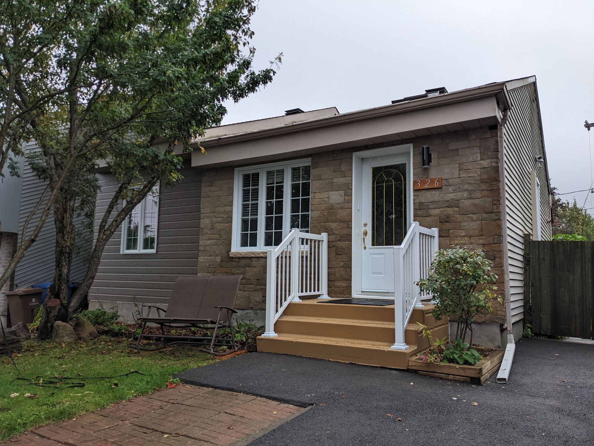 Une petite maison en brique avec une porte et des escaliers blancs