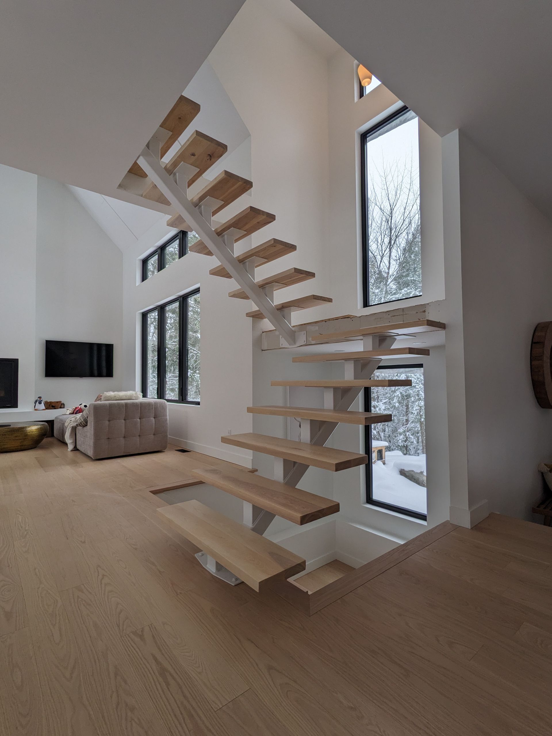 Un escalier en bois mène au deuxième étage d'une maison.