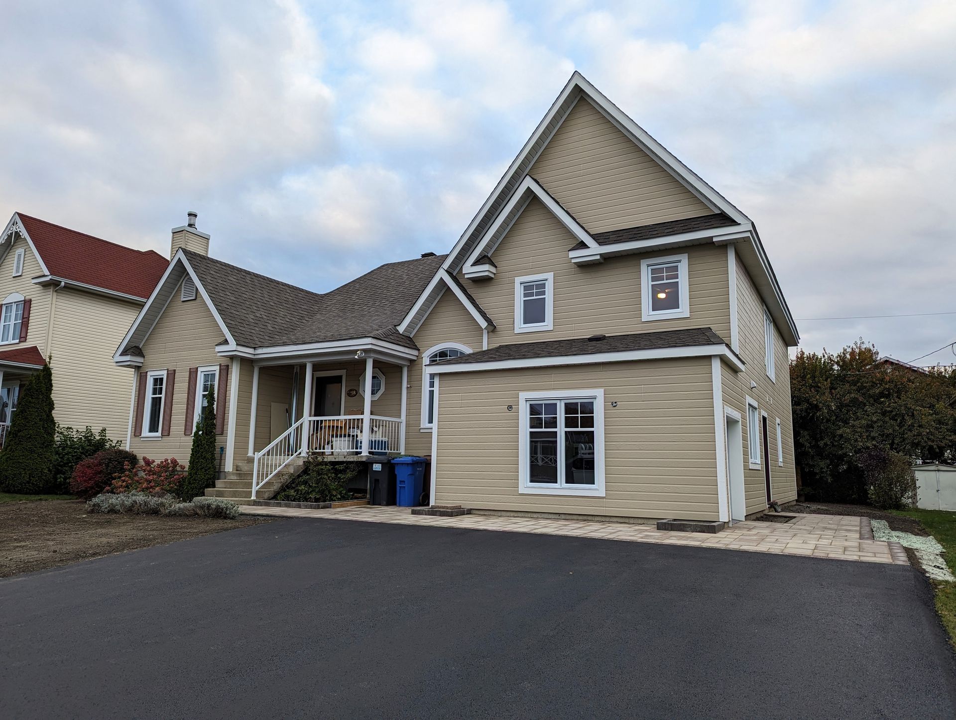 Une grande maison avec un garage et une tente devant.