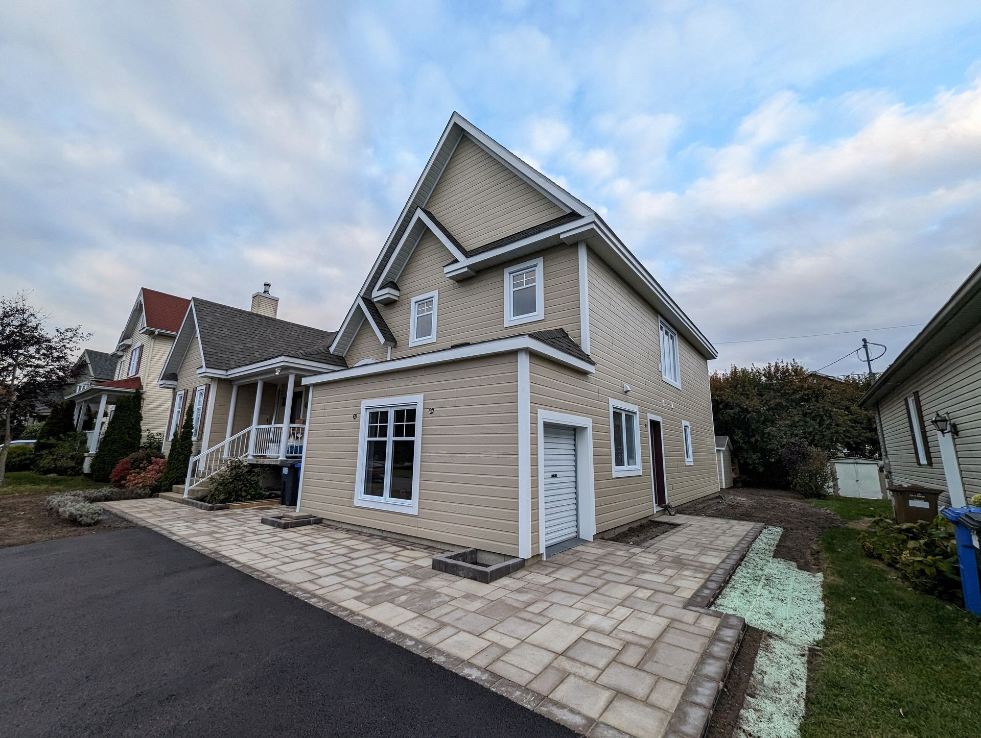 Une grande maison avec beaucoup de fenêtres et une allée devant.