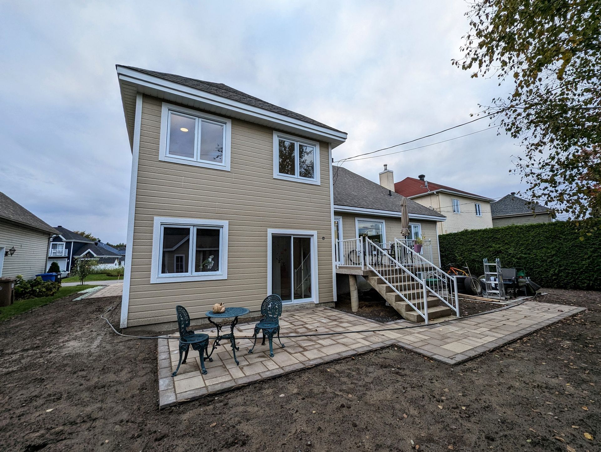 Une grande maison avec une terrasse dans l'arrière-cour est recouverte de neige.