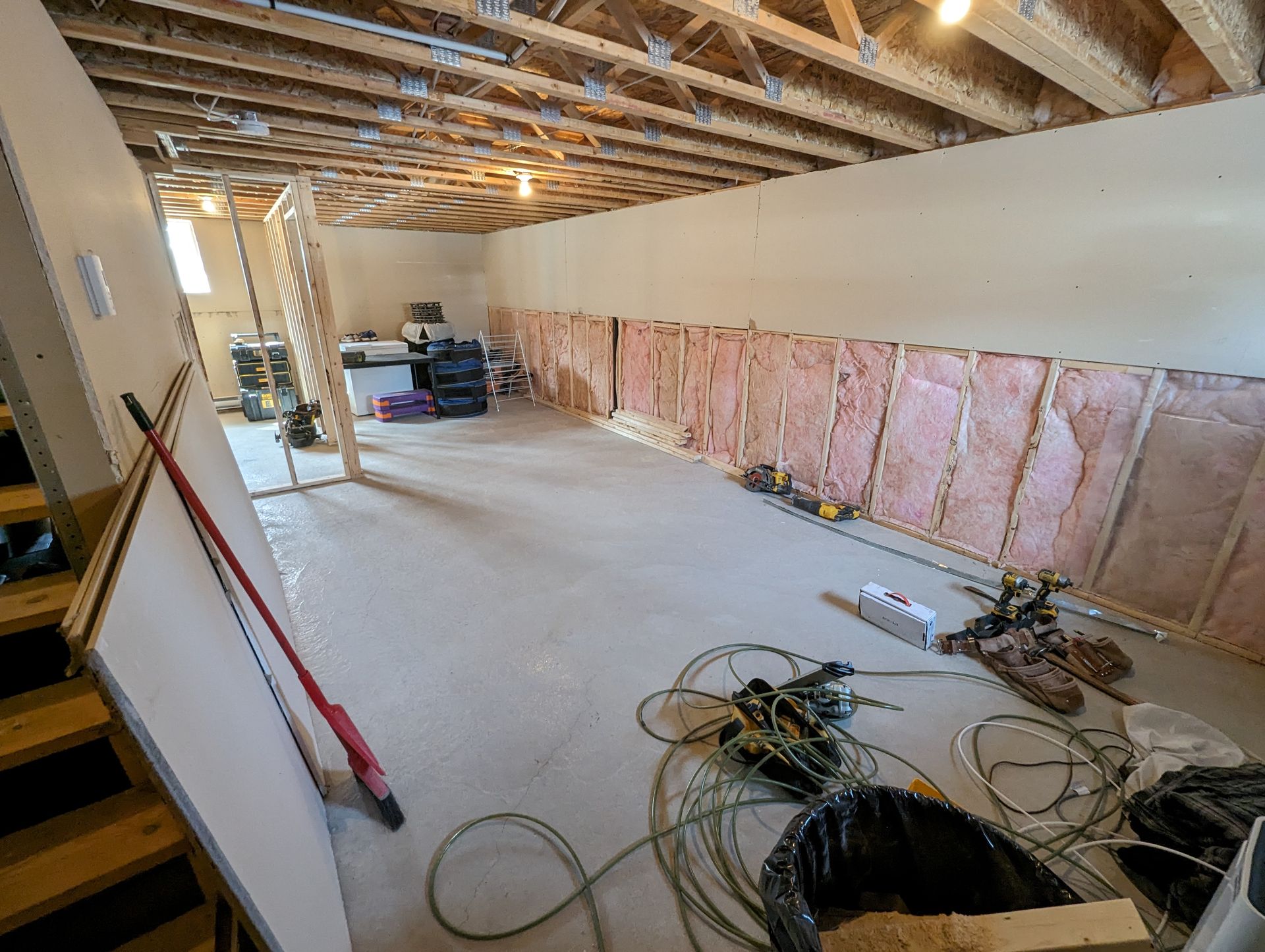 Un sous-sol en construction avec beaucoup d'outils au sol.