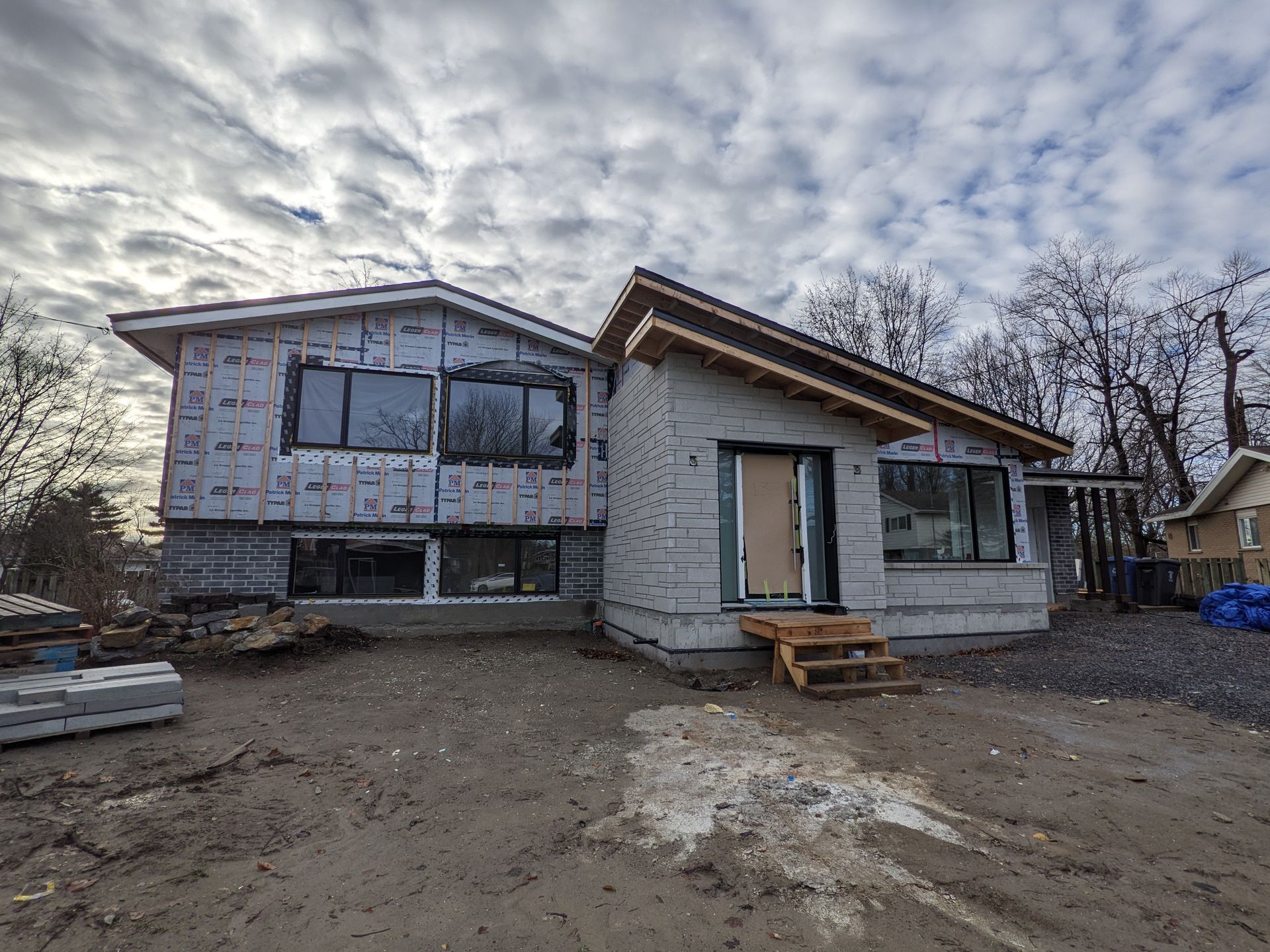 Une maison est en construction au milieu d'un champ de terre.