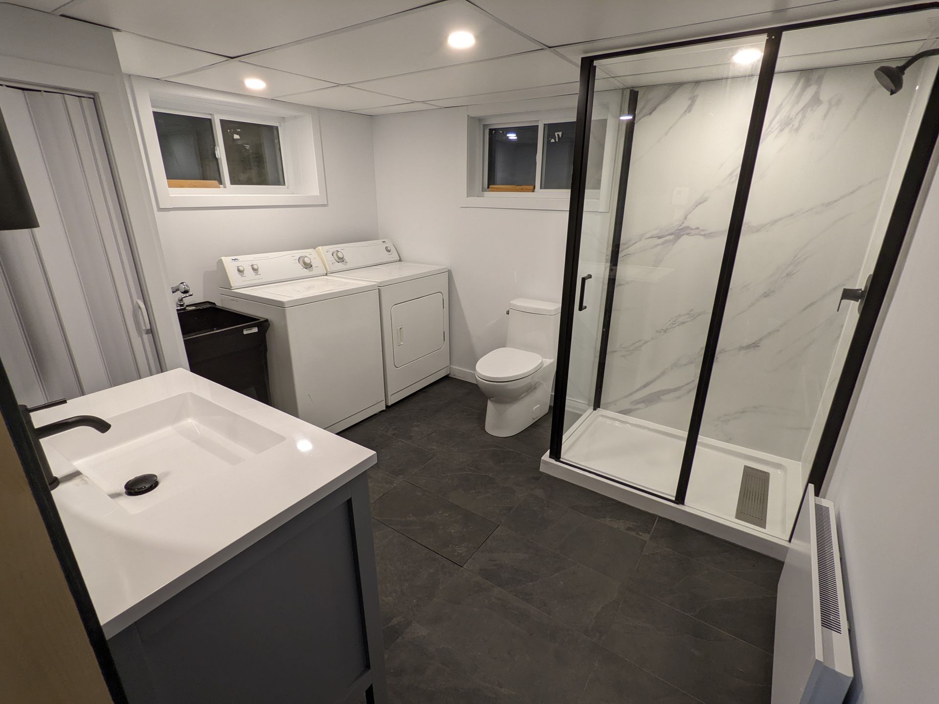 Une salle de bain avec WC , lavabo et douche.