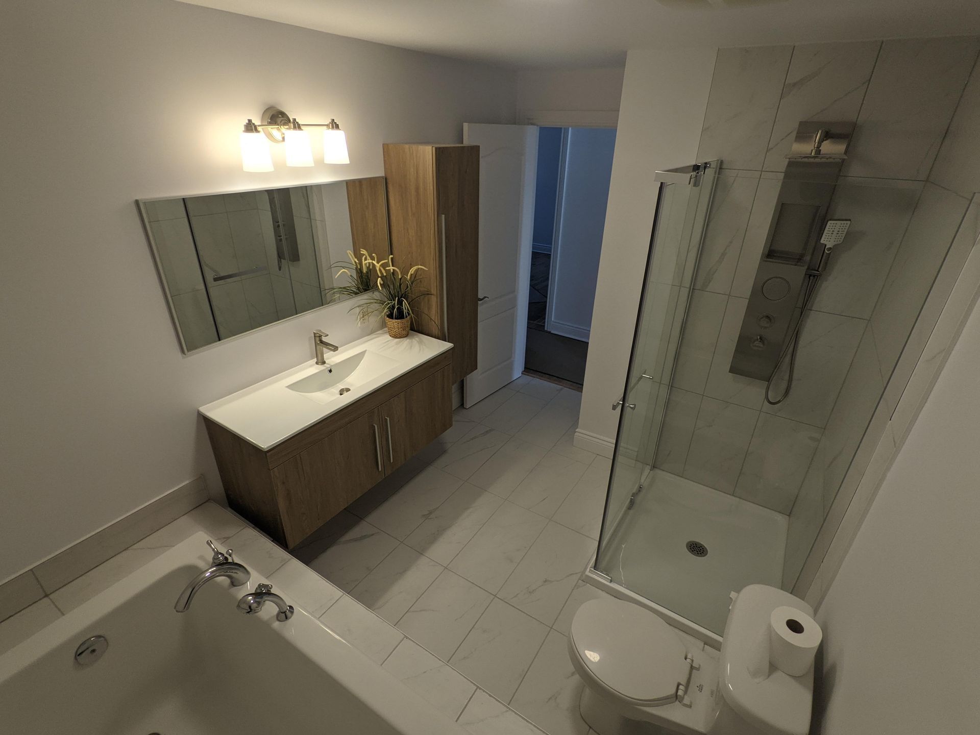 Une salle de bain avec baignoire , WC , lavabo et douche.