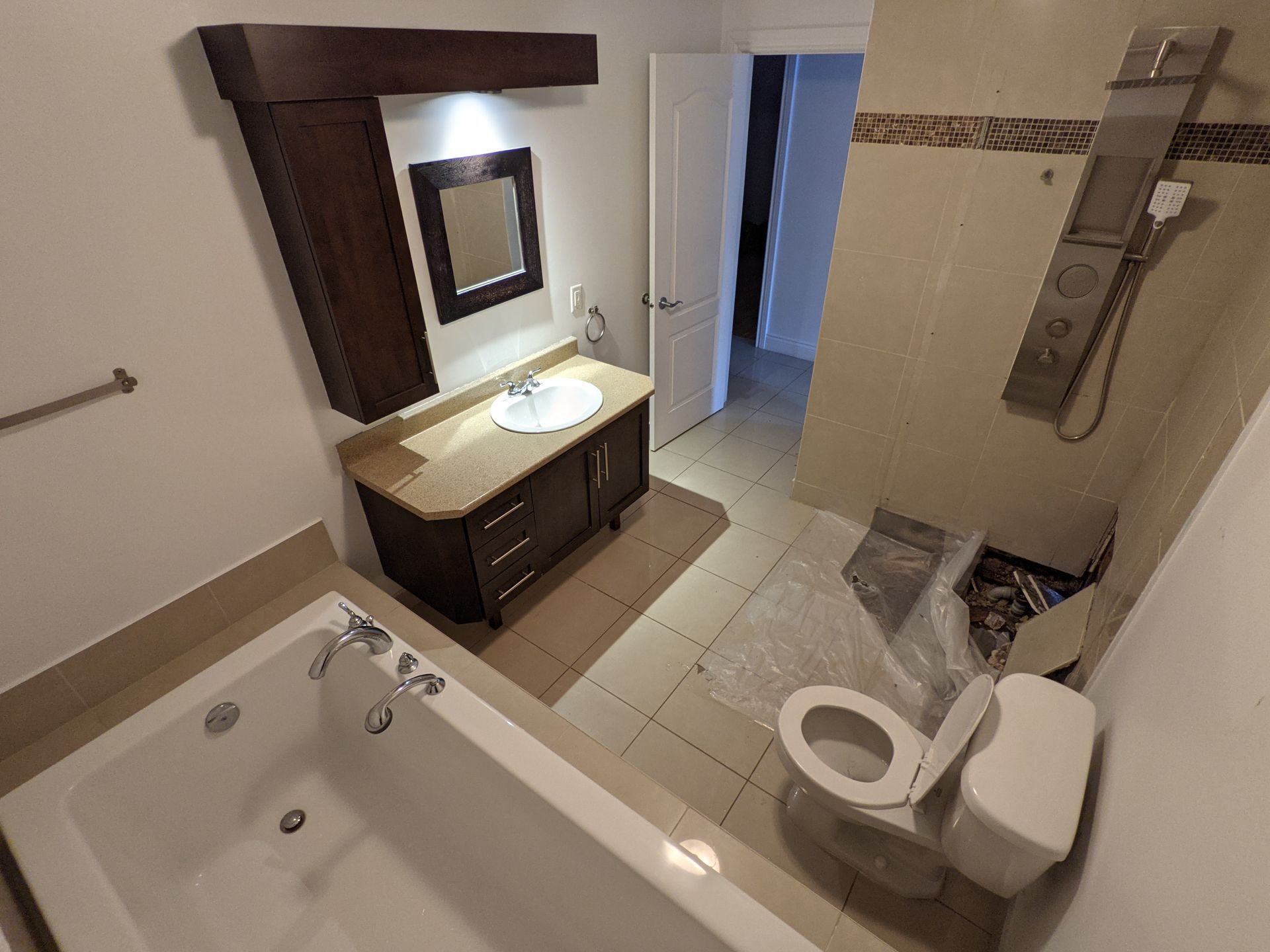 Une salle de bain avec baignoire , WC , lavabo et miroir.