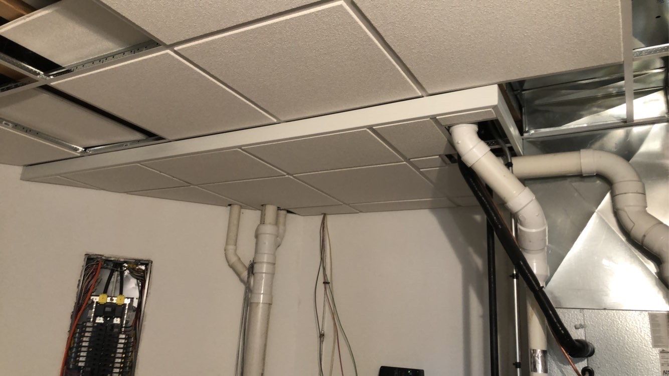 Custom basement ceiling remodeling to hide plumbing and electrical lines in Lansing, Iowa.