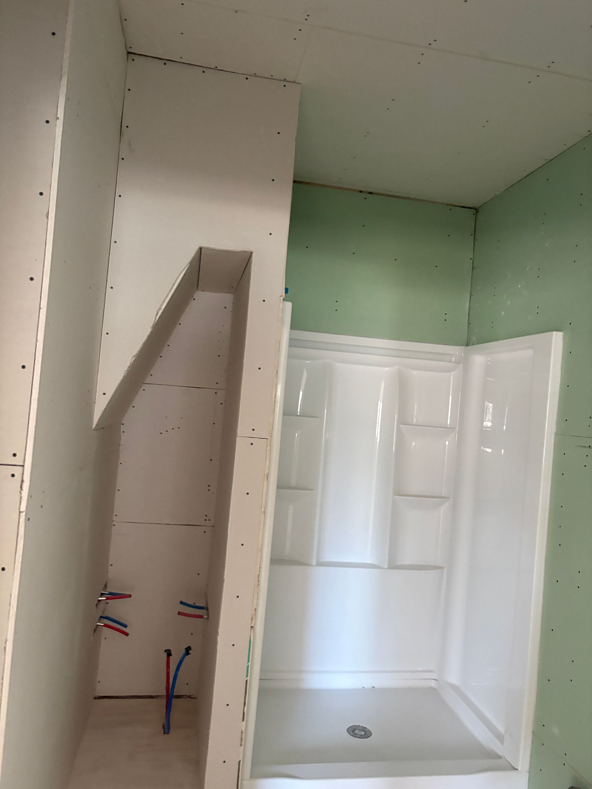 Bathroom remodeling in Lansing, Iowa, featuring new shower installation and rough-in plumbing.