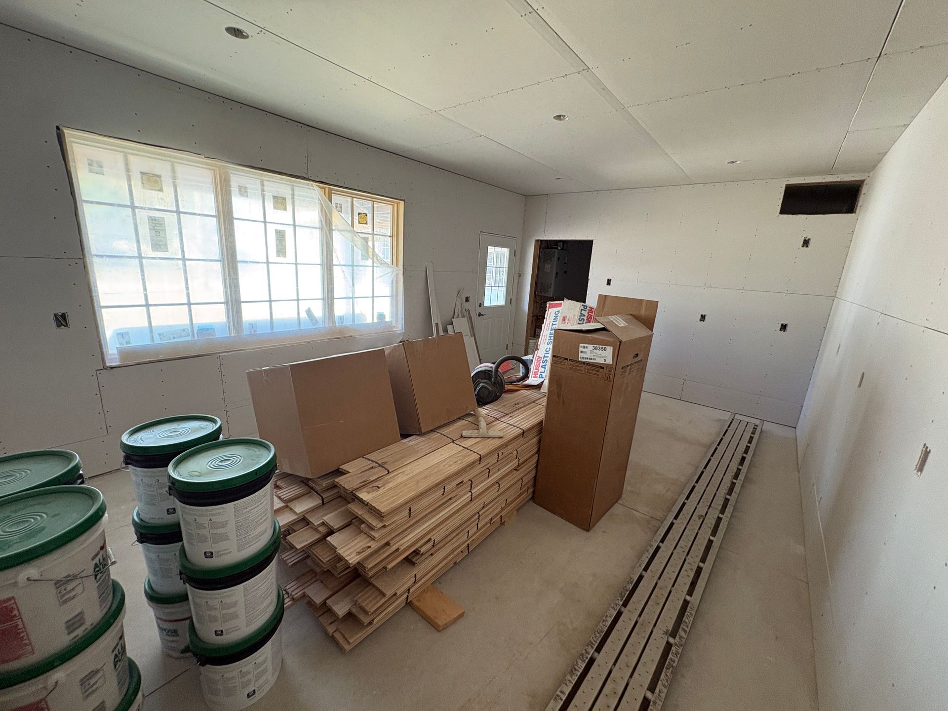 Interior home remodeling in Lansing, Iowa, showing staged construction materials and new drywall.