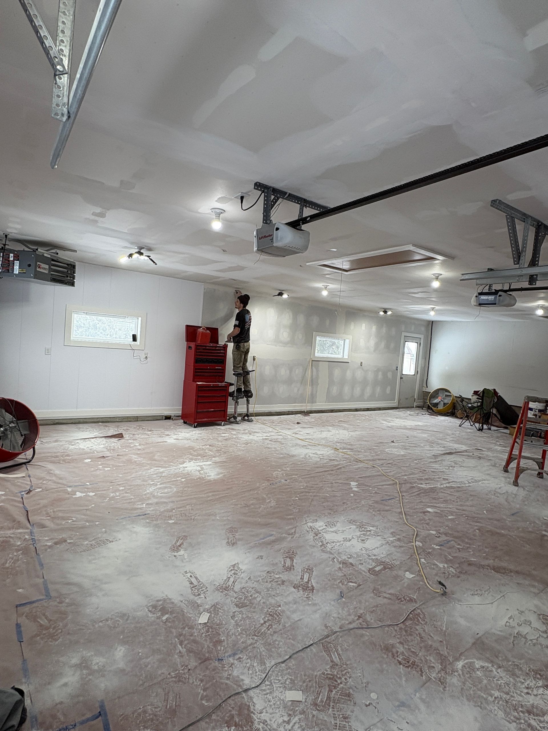 Large interior garage remodeling project with finished drywall and high ceilings in Lansing, Iowa.