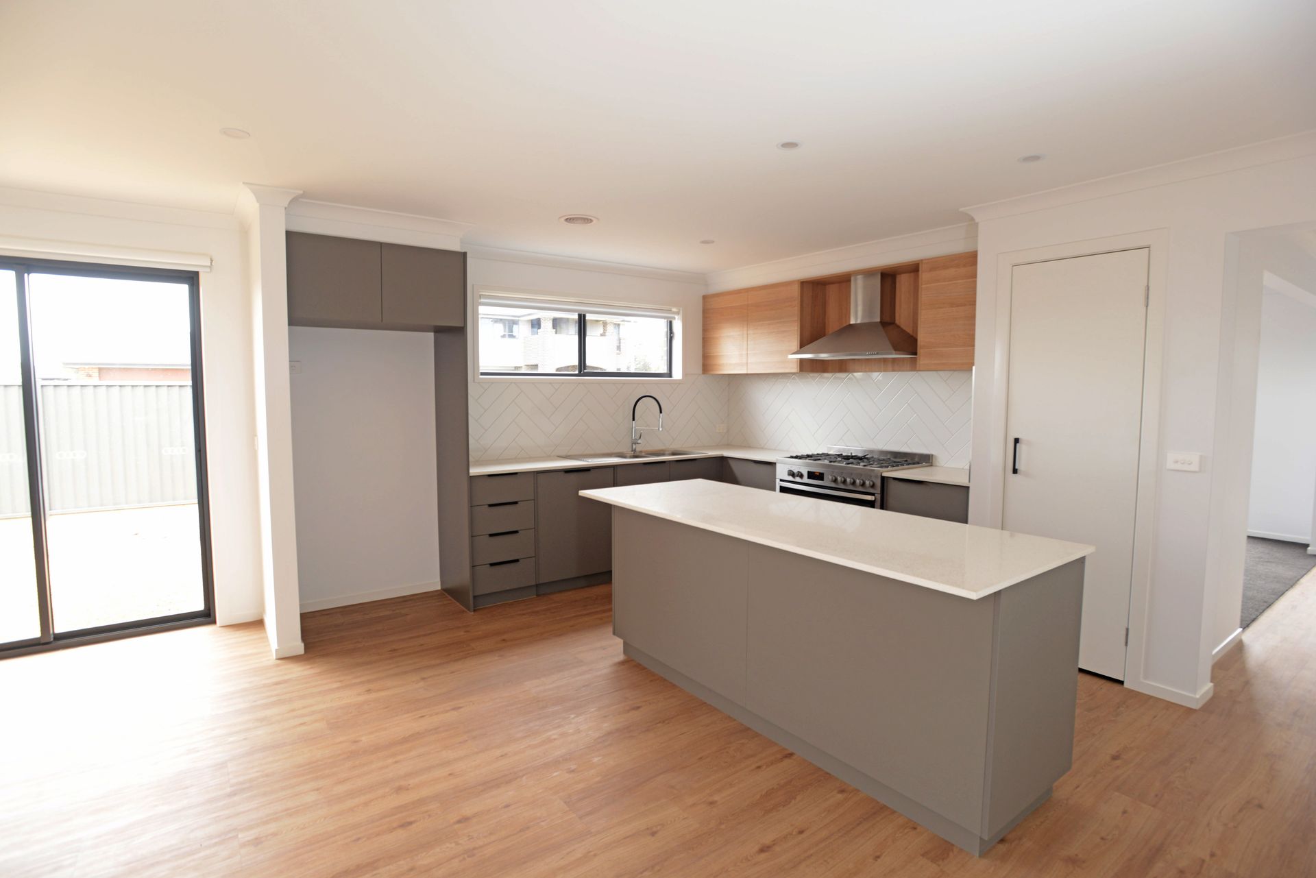 An Empty Kitchen With a Large Island in the Middle of the Room — Evoke Building Group In Ballarat Central, VIC