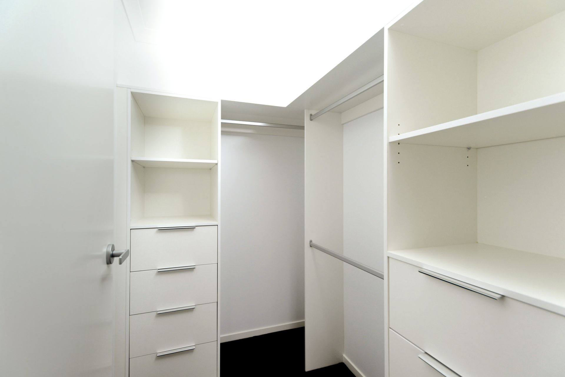 An Empty Walk in Closet With White Shelves and Drawers — Evoke Building Group In Ballarat Central, VIC