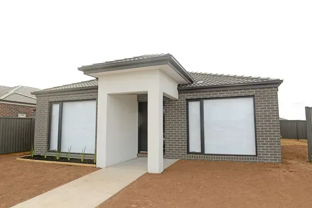 A Brick House With a Black Garage Door — Evoke Building Group In Ballarat Central, VIC