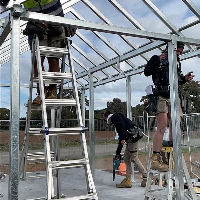 A Man Wearing a Gas Mask is Kneeling Down in a Room — Evoke Building Group In Ballarat Central, VIC